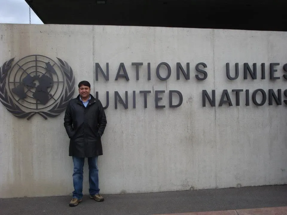 Sumit Singh beside the United Nations emblem in Geneva