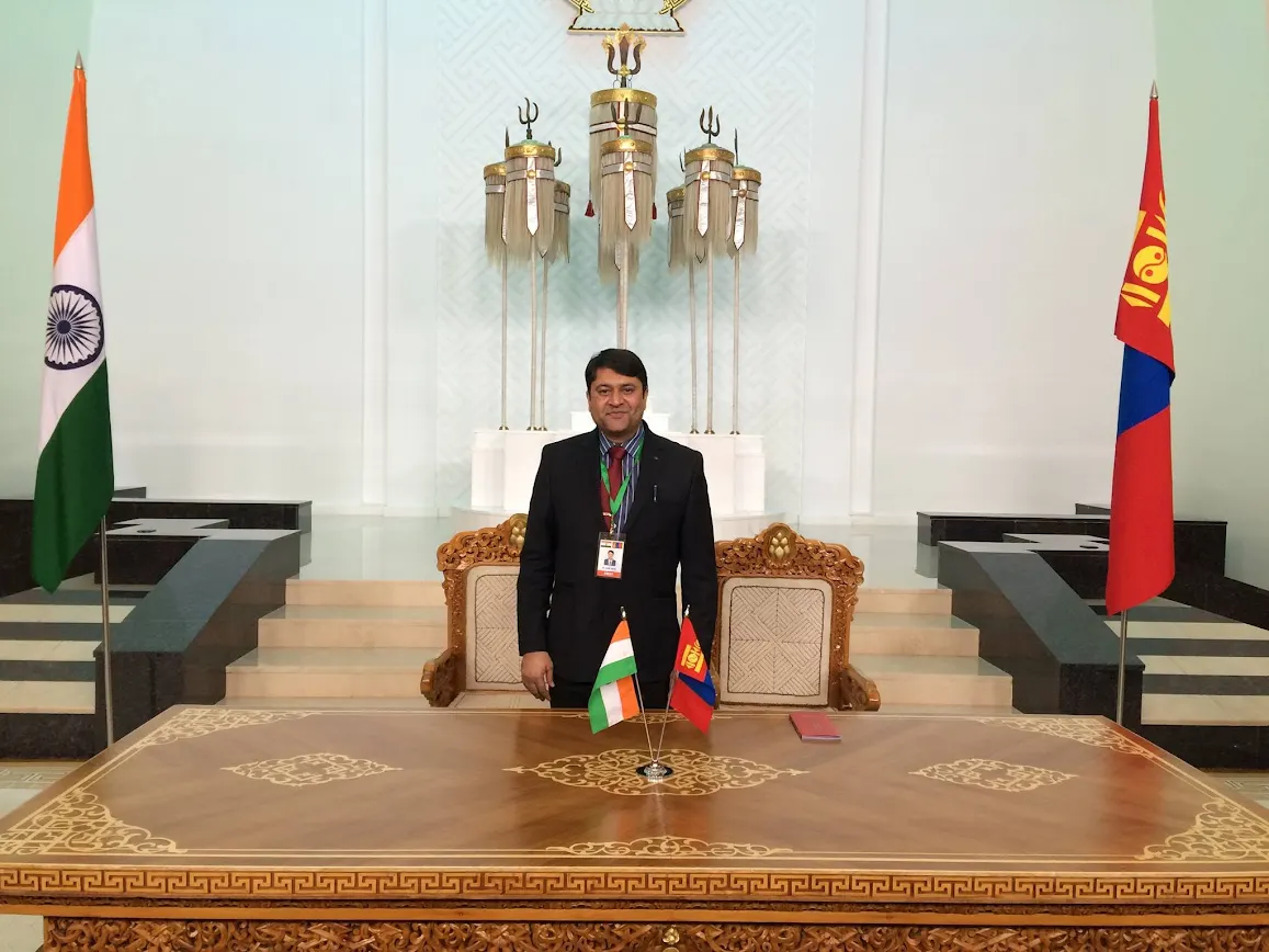 Sumit Singh at a meeting table with the Indian and Mongolian flags